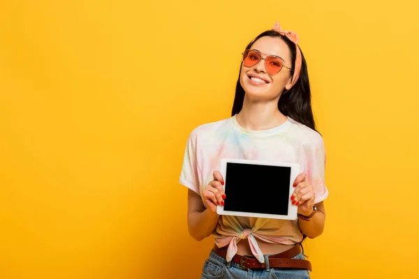 Sorrindo elegante verão morena menina segurando tablet digital com tela em branco no fundo amarelo — Fotografia de Stock