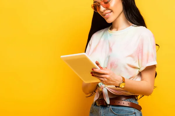 Abgeschnittene Ansicht des Lächelns stilvolle Sommer Brünette Mädchen mit digitalem Tablet auf gelbem Hintergrund — Stockfoto