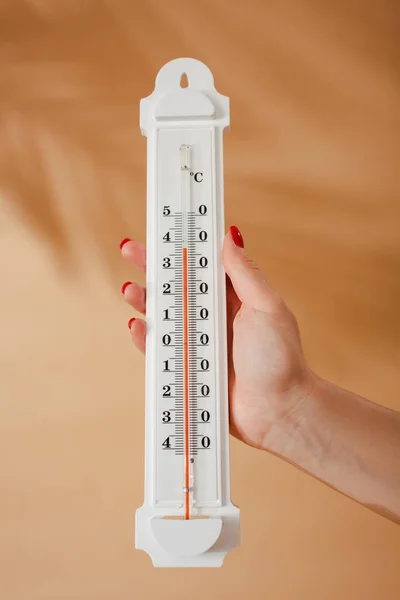 Vue recadrée du thermomètre femme tenant sur fond beige — Photo de stock