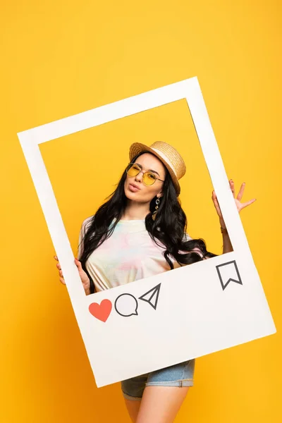 Brunette girl in summer outfit posing pouting lips in social network frame on yellow background — Stock Photo