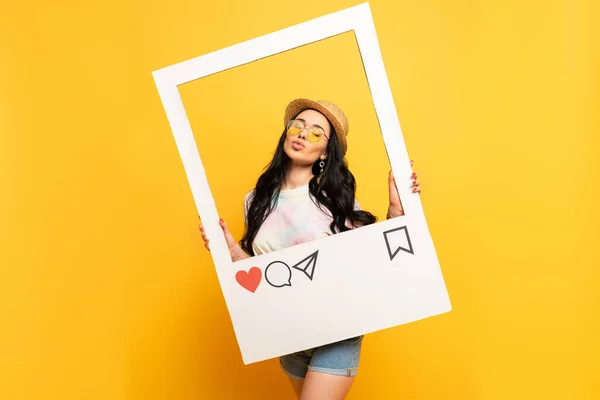 Brunette girl in summer outfit posing pouting lips in social network frame on yellow background — Stock Photo