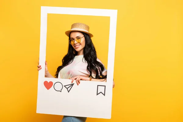 Lächelnde Brünette im Sommer-Outfit posiert in sozialem Netzwerk-Rahmen auf gelbem Hintergrund — Stockfoto