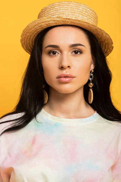 Brunette girl in straw hat isolated on yellow — Stock Photo