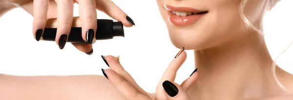 Vue recadrée d'une femme nue souriante aux ongles noirs qui applique un fond de teint sur les doigts isolés sur une photo panoramique blanche — Photo de stock