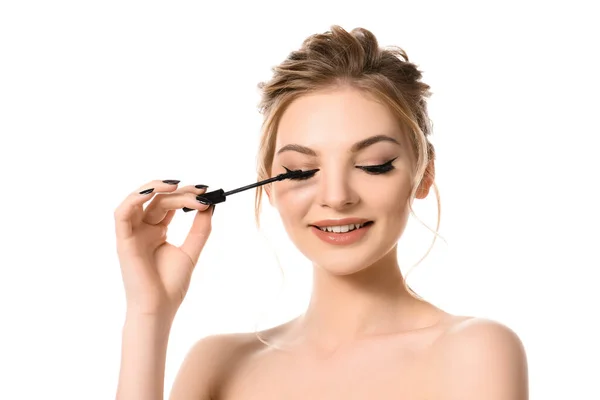 Sorrindo nu bela mulher loira com maquiagem e unhas pretas aplicando rímel isolado no branco — Fotografia de Stock