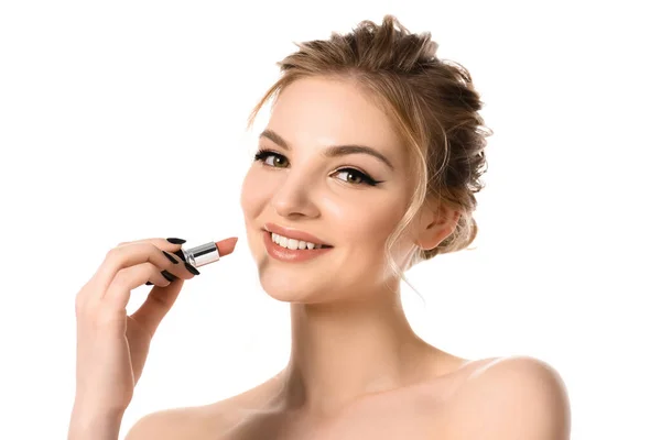 Sonriendo desnuda hermosa mujer rubia sosteniendo lápiz labial beige aislado en blanco - foto de stock