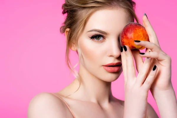 Elegant beautiful blonde woman holding peach isolated on pink — Stock Photo