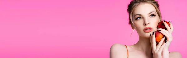 Elegant beautiful blonde woman holding peaches isolated on pink, panoramic shot — Stock Photo
