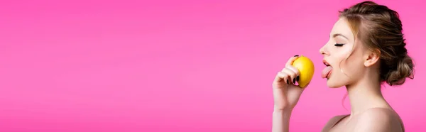 Vista lateral de la hermosa mujer rubia lamiendo limón maduro aislado en rosa, tiro panorámico - foto de stock