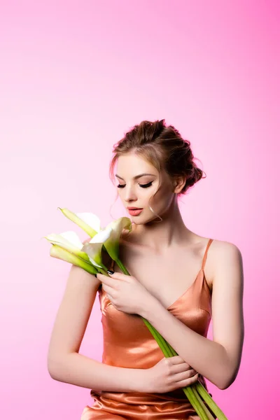 Mulher loira bonita elegante segurando flores calla isolado em rosa — Fotografia de Stock