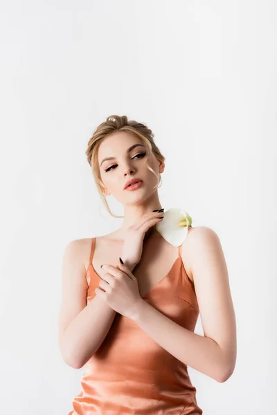 Elegante hermosa mujer rubia sosteniendo flor de calla en el hombro aislado en blanco - foto de stock