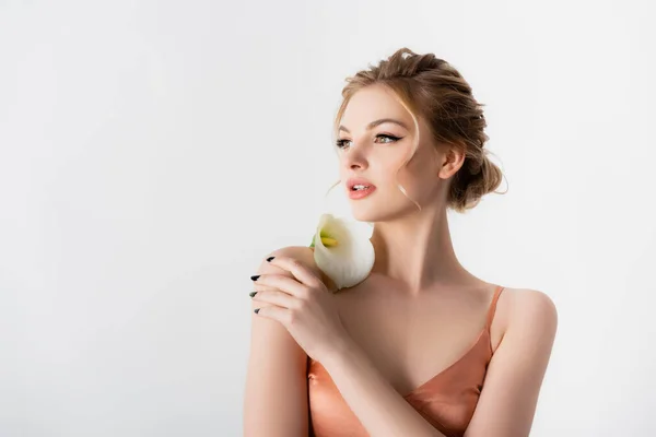 Elegant beautiful blonde woman holding calla flower on shoulder isolated on white — Stock Photo