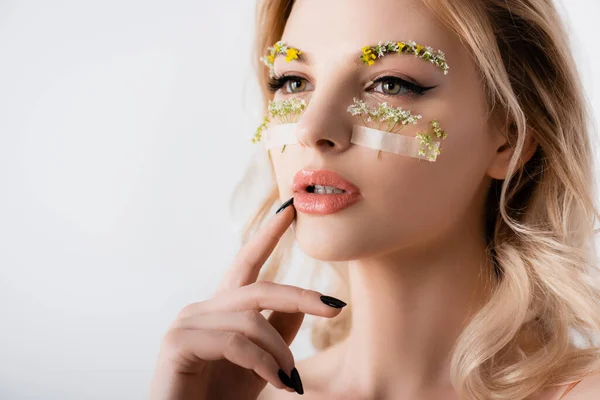 Nackte schöne blonde Frau im Seidenkleid mit Wildblumen unter den Augen, die isoliert auf weiß wegschauen — Stockfoto