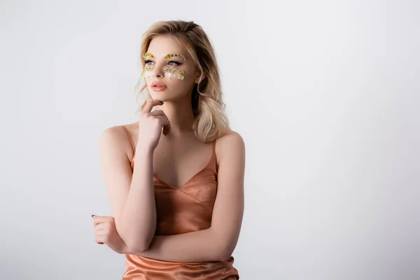 Dreamy beautiful blonde woman in silk dress with wildflowers under eyes isolated on white — Stock Photo