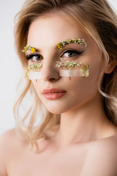 Nue belle femme blonde avec des fleurs sauvages sous les yeux isolés sur blanc — Photo de stock