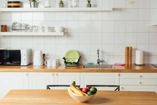 Frutos frescos em tigela na mesa de madeira na cozinha — Fotografia de Stock