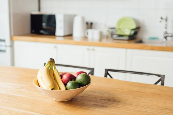 Foco seletivo de frutas maduras em mesa de madeira na cozinha — Fotografia de Stock