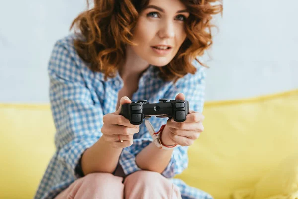 KYIV, UKRAINE - JUNE 19, 2020: selective focus of young woman playing video game with joystick — Stock Photo