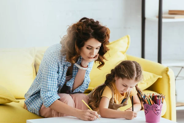 Selective focus of babysitter and cute kid drawing with pencils — Stock Photo