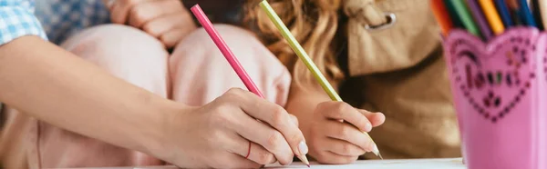 Cropped view of nanny and child drawing with pencils together, horizontal image — Stock Photo