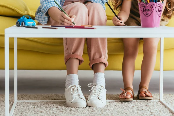 Vue recadrée de nounou et dessin d'enfant avec des crayons ensemble — Photo de stock