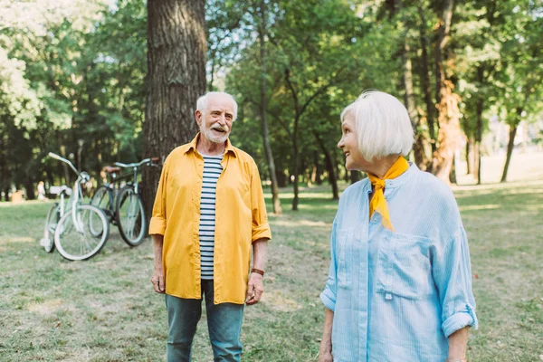 Selektiver Fokus eines positiven Seniors, der Frau im Sommer im Park anschaut — Stockfoto