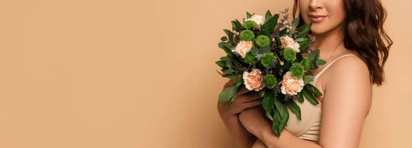 Partial view of young pregnant woman holding bouquet of fresh flowers on beige, horizontal concept — Stock Photo