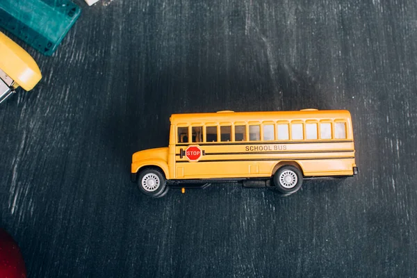 Top view of yellow school bus model with stop sign on black chalkboard — Stock Photo