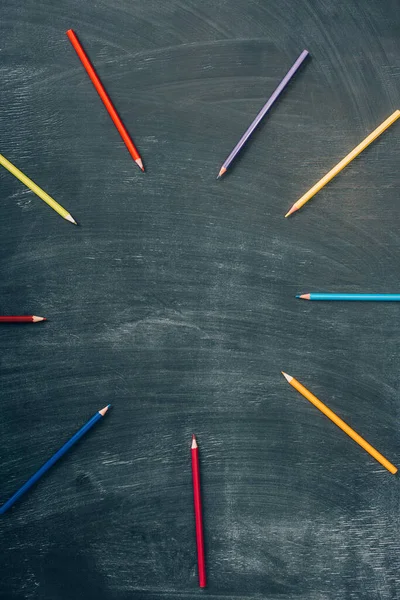 Top view of empty frame of multicolored pencils on green chalkboard — Stock Photo