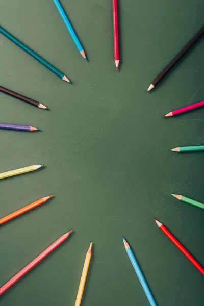 Top view of empty frame of color pencils on green chalkboard — Stock Photo