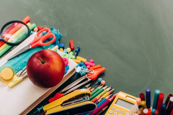 Вибірковий фокус смачного яблука на книзі біля шкільного приладдя, високий кут зору — стокове фото