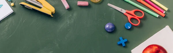 Top view of school stationery on green chalkboard, panoramic crop — Stock Photo