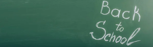 Top view of back to school inscription on green chalkboard, horizontal image — Stock Photo