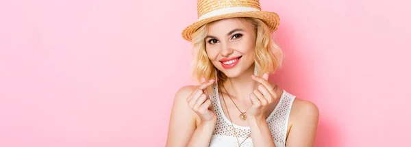 Panoramic crop of woman in straw hat showing money gesture with hands on pink — Stock Photo