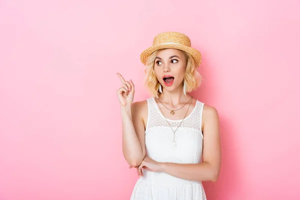 Excited woman in straw hat having idea on pink — Stock Photo