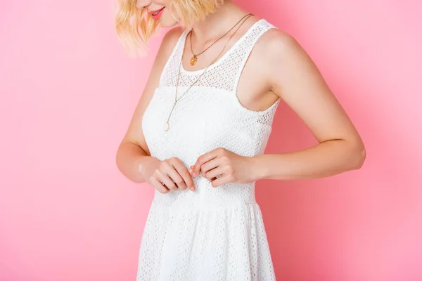 Cropped view of young woman in white dress on pink — Stock Photo