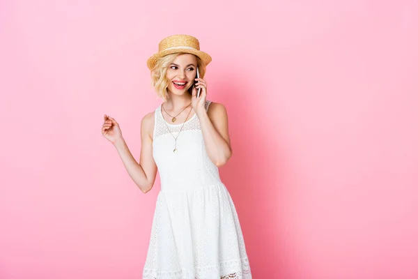 Femme en paille chapeau et robe parler sur smartphone sur rose — Photo de stock