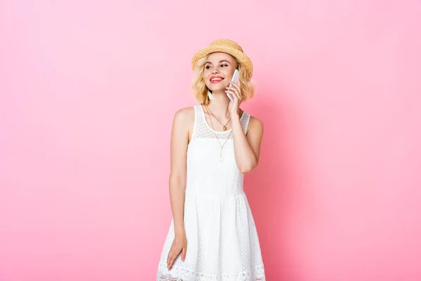 Woman in straw hat talking on smartphone and standing on pink — Stock Photo