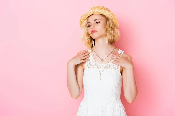 Tired young woman in straw hat and white dress on pink — Stock Photo
