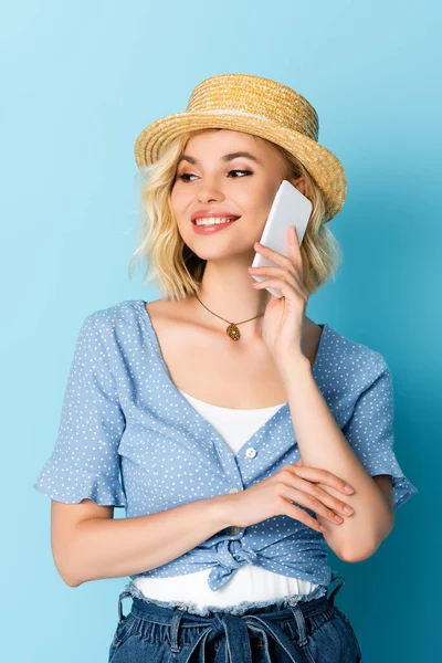 Frau mit Strohhut redet auf Smartphone auf blau — Stockfoto