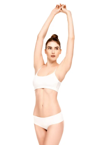 Woman with perfect body in panties and top standing with hands above head isolated on white — Stock Photo