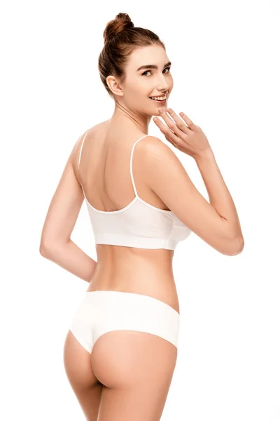 Donna con corpo perfetto in mutandine e top standing e toccare il viso isolato su bianco — Foto stock