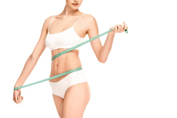 Vista recortada de la mujer que mide la cintura con cinta métrica aislada en blanco - foto de stock