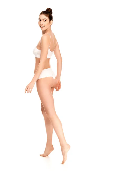 Mujer descalza con el cuerpo perfecto mirando hacia otro lado y caminando sobre blanco - foto de stock