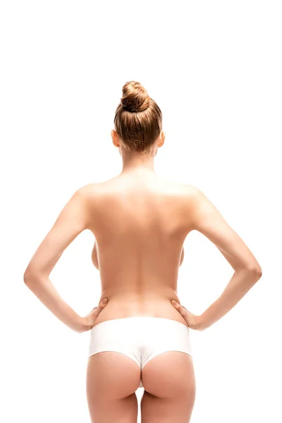Вид ззаду молодої жінки, що стоїть з руками на стегнах ізольовано на білому — стокове фото