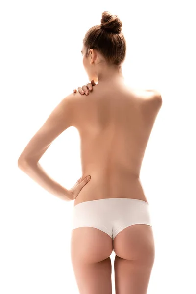 Vista posteriore di giovane donna in mutandine in piedi con mano sul fianco isolato su bianco — Foto stock