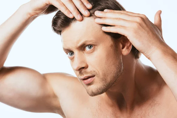 Uomo preoccupato toccando i capelli e guardando lontano isolato su bianco — Foto stock