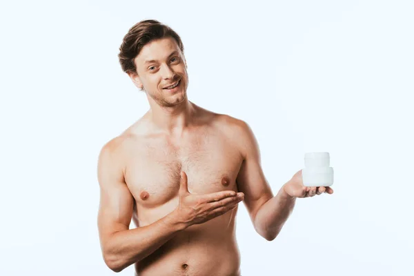 Homem sem camisa apontando com a mão para frascos de cremes cosméticos isolados em branco — Fotografia de Stock