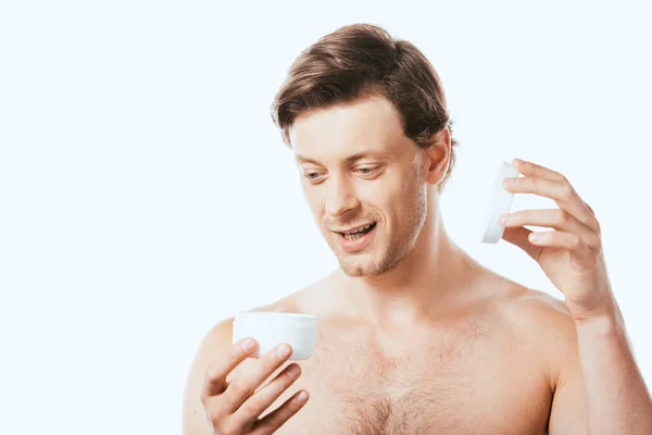 Joven hombre sin camisa abriendo tarro de crema cosmética aislado en blanco — Stock Photo