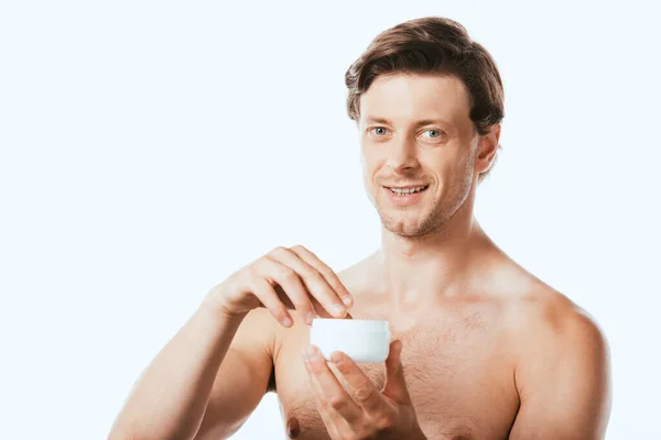 Hombre sin camisa sosteniendo crema cosmética y mirando a la cámara aislada en blanco - foto de stock